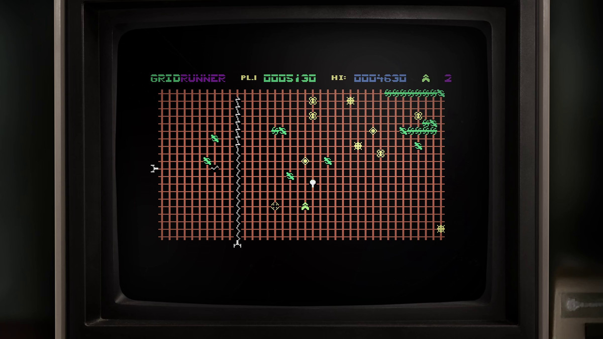 A screenshot of Gridrunner, framed by an old TV monitor, showing its simple 8-bit graphics