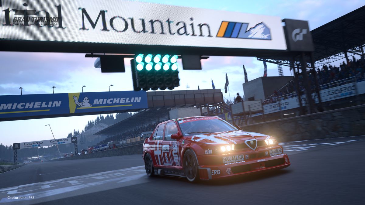 an Alfa Romeo racing car crossing the finish line on the Trial Mountain circuit in Gran Turismo 7