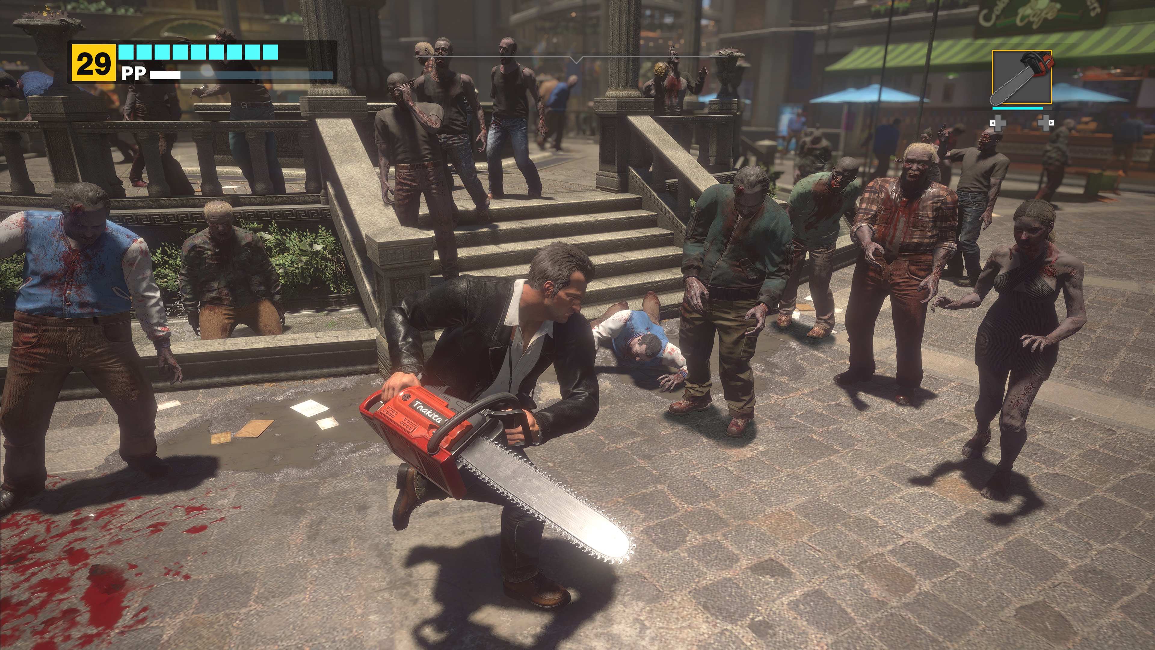 Frank West attacks a horde of zombies with a chainsaw in a screenshot from Dead Rising Deluxe Remaster