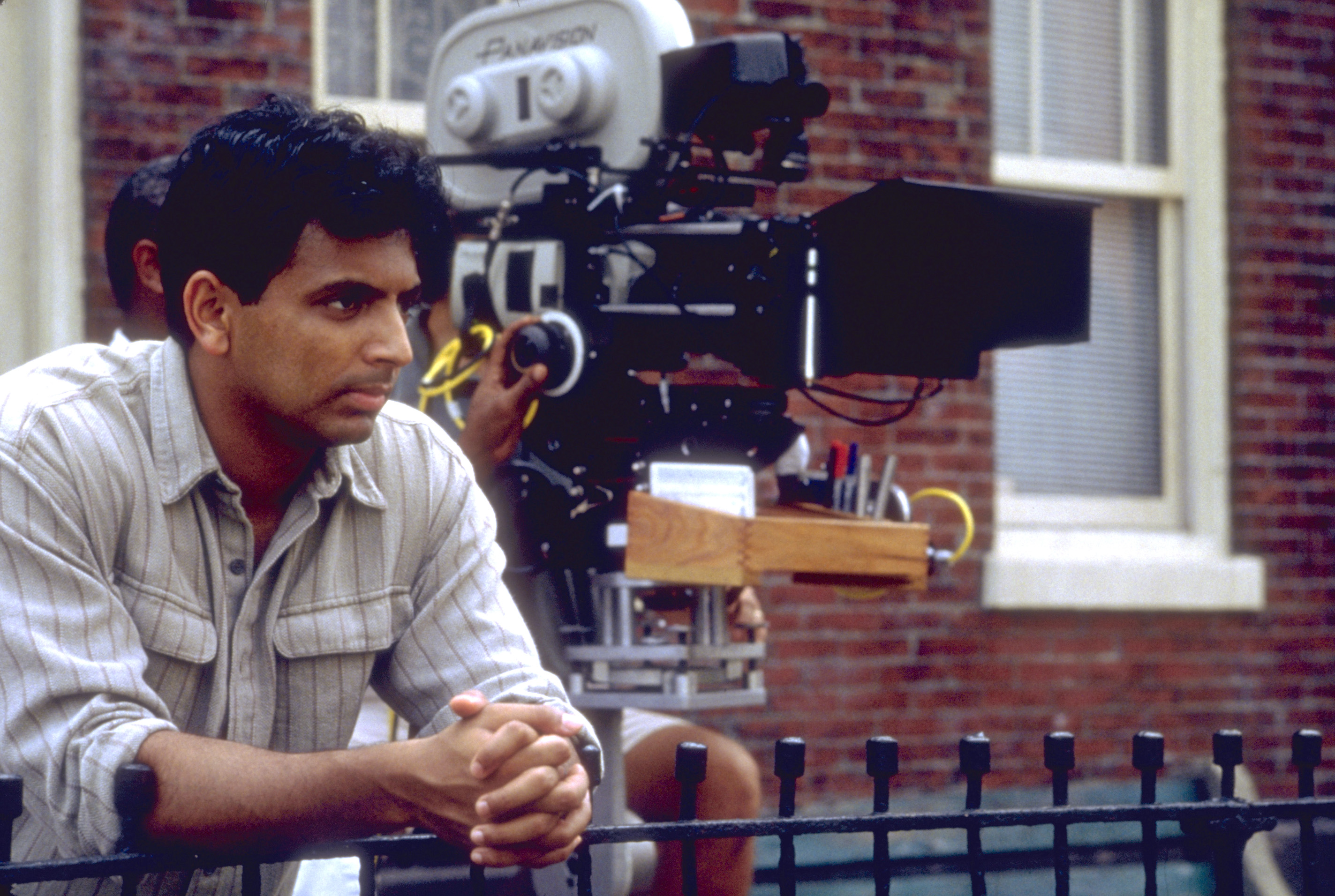 M. Night Shyamalan standing next to a camera on the set of The Sixth Sense 