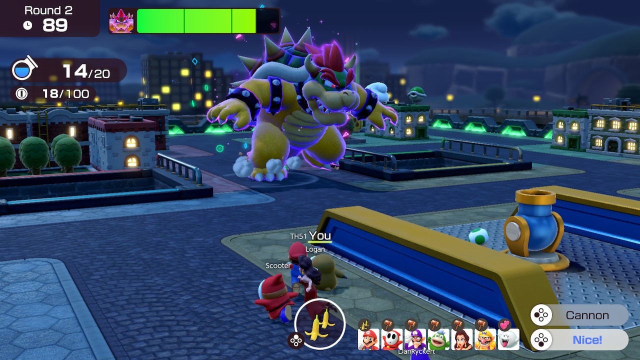 A screenshot of Super Mario Party Jamboree featuring some of the game’s characters hiding from a stampeding Bowser on an urban rooftop