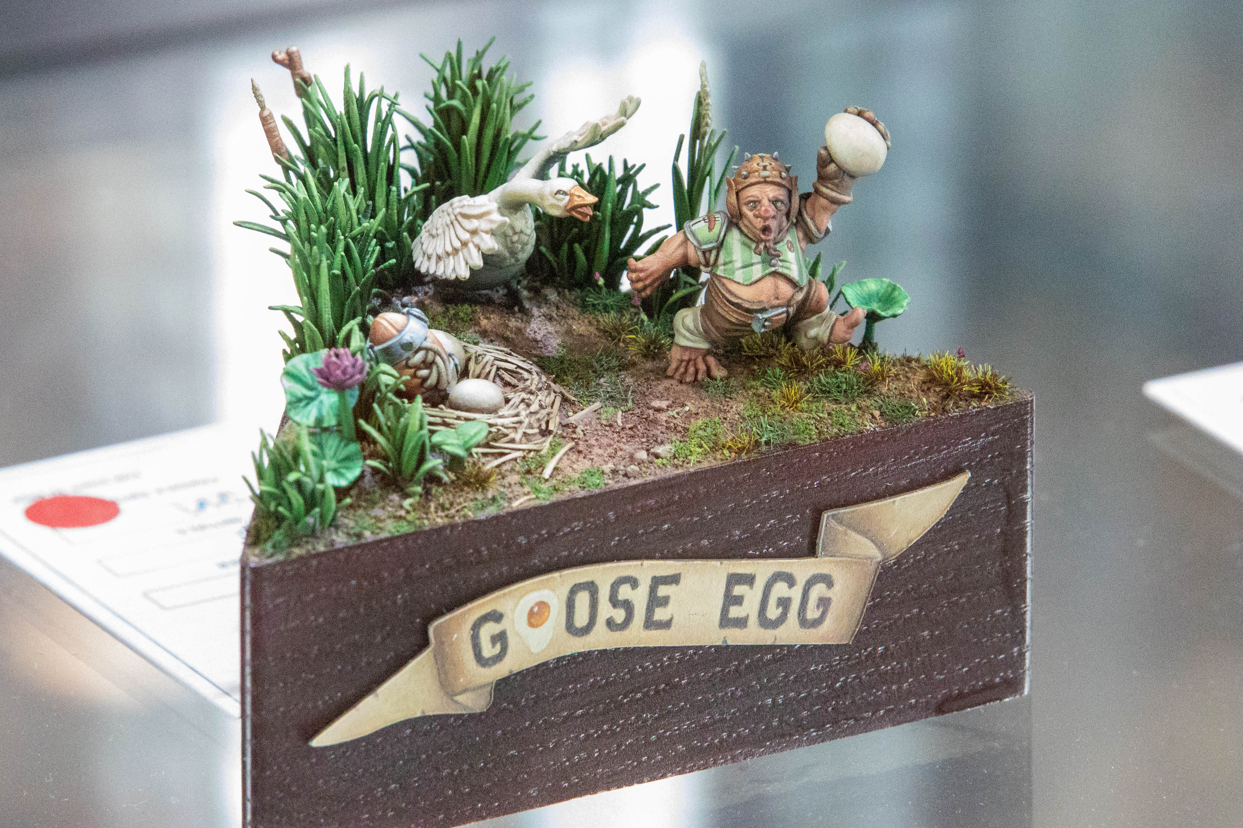 A model showing an Ork running from a goose holding an egg, with the legend Goose Egg