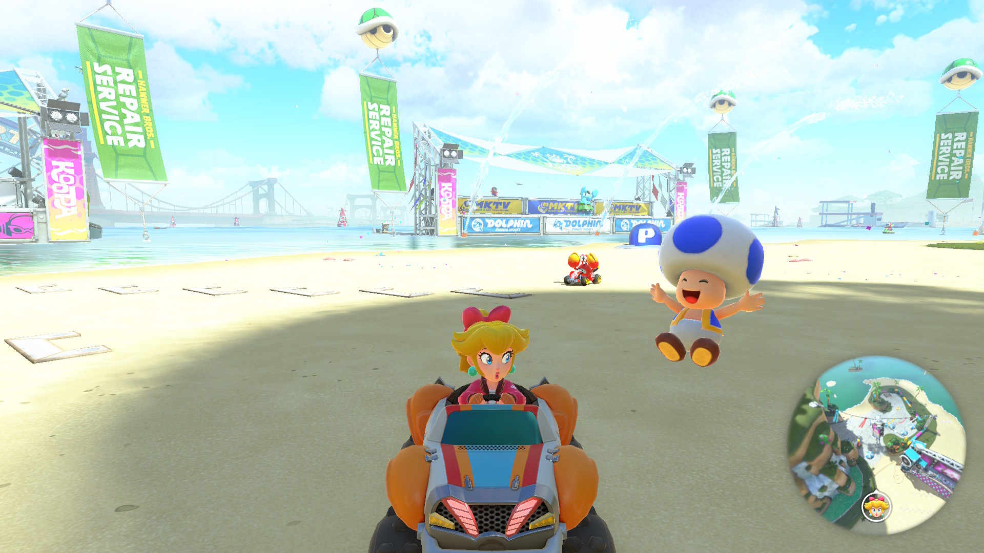 Peach looking surprised as a Toad waves at her on the Koopa Beach course in Mario Kart World