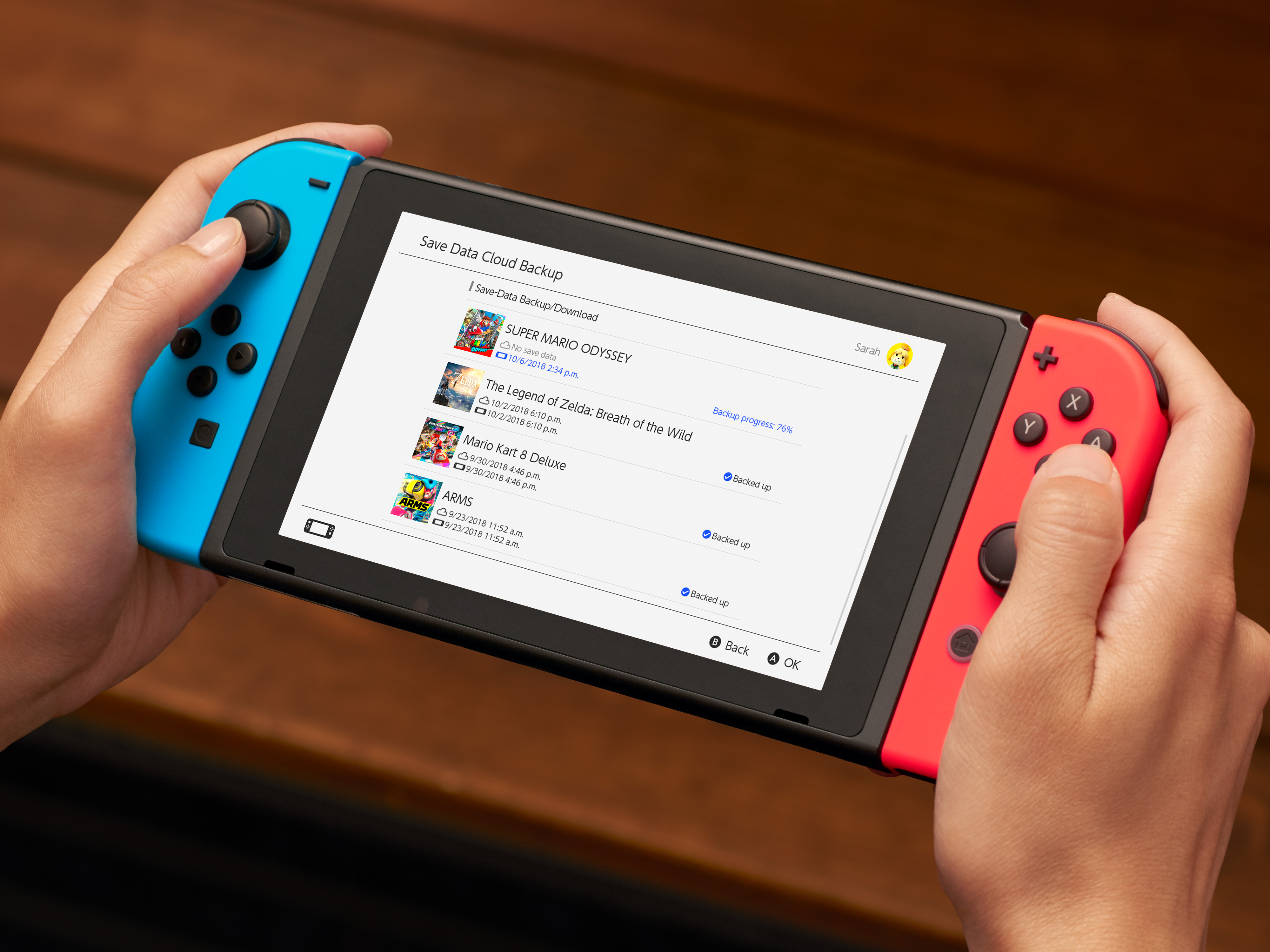 A photo of a person holding a Nintendo Switch. The screen shows a menu for the eshop store.